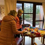 Omagh Carers Knitting Group members Joy Aiken and Beth Wylie admire a large selection of beautifully hand knitted twiddle muffs and blankets donated to Meadowbank Residential Home.