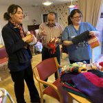 Clare Lafferty, Manager, Meadowbank Residential Home, Tony Cassidy, Resident and Clare Walsh, Care Worker admiring the beautifully hand knitted twiddle muffs and blankets kindly donated by the Omagh Carers Knitting Group.