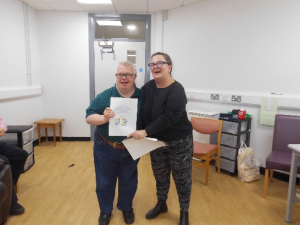 Service User receives their certificate for completing the Safer Eating and Drinking Programme from Janice McAllister