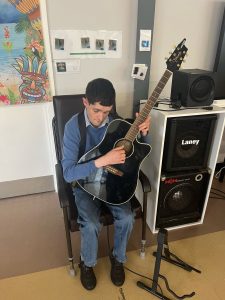 Service User playing the guitar