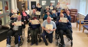 Drumcoo Day Centre Service Users with their certificates for completing the Living Life to the Full Course