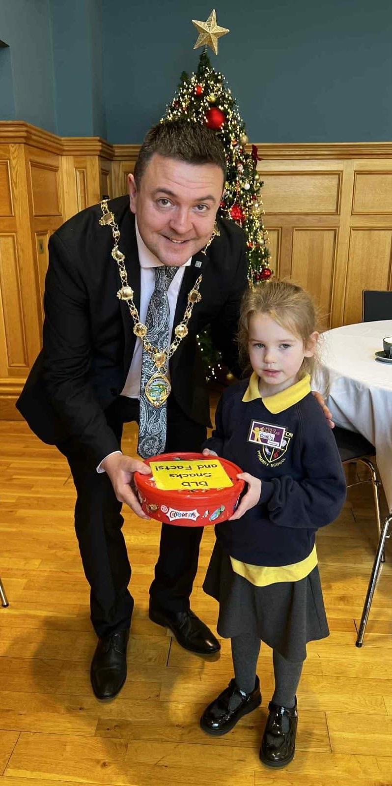 Cadhla McGrath, pupil in Ebrington Speech and Language Class, presenting the Mayor with 'DLD snacks and facts' to help raise awareness of DLD