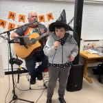 Service User At Omagh Day Centre Singing At The Halloween Party With Musician