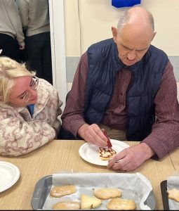 Service User And Staff Member Doing Some Christmas Baking