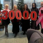 Staff with numbers donating £30000 to a breast cancer charity