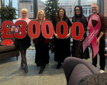 Staff with numbers donating £30000 to a breast cancer charity