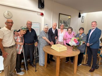 Staff and Service Users at Thackeray Residential Home cutting a cake to mark 50 years