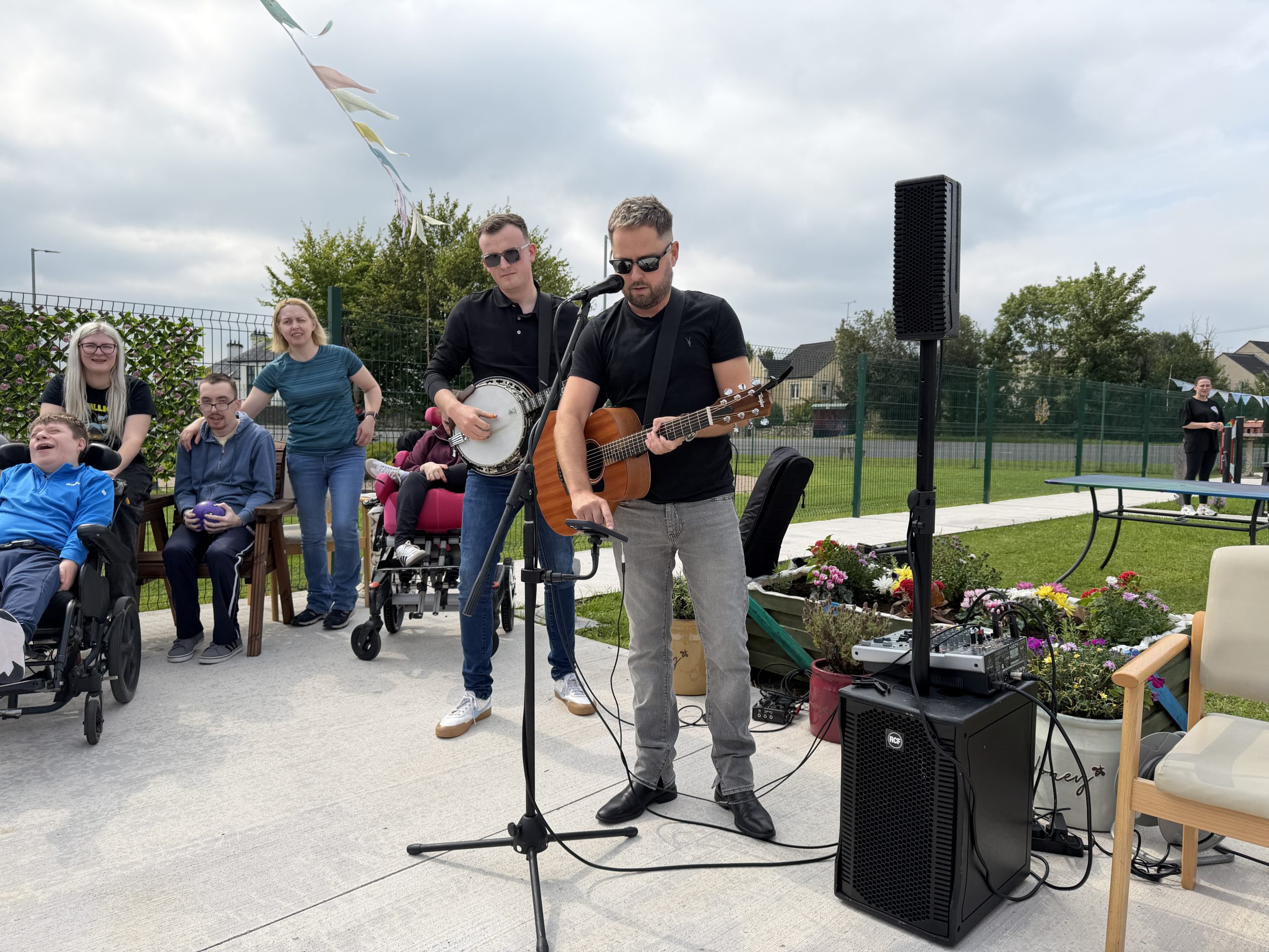 Musicians with banjo and guitar in garden setting
