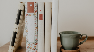 a row of books beside a cup