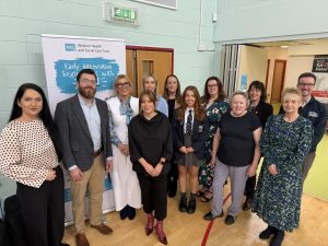 Large group of people standing in front of pull up banner promoting Early Intervention Animation Launch